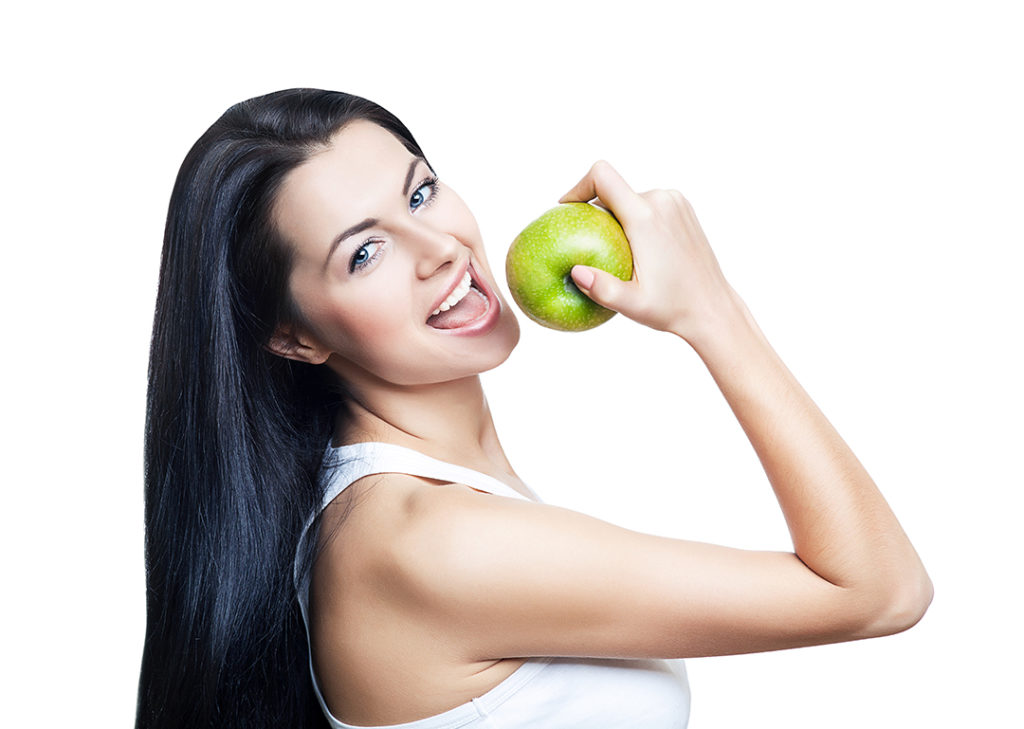 A woman holding a green apple