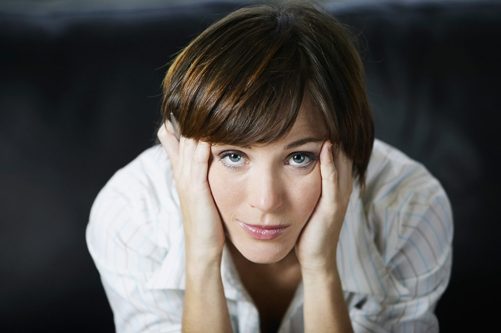 A picture of a stressed woman looking up at the camera