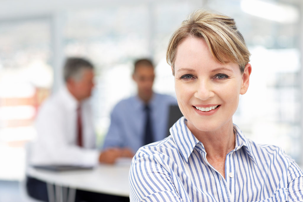 A woman in the workplace wearing a striped shirt