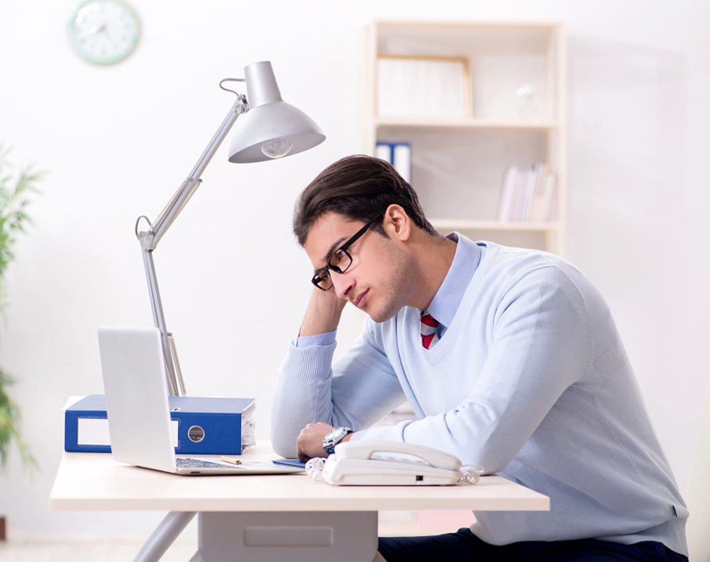 Young handsome businessman employee working in office at desk