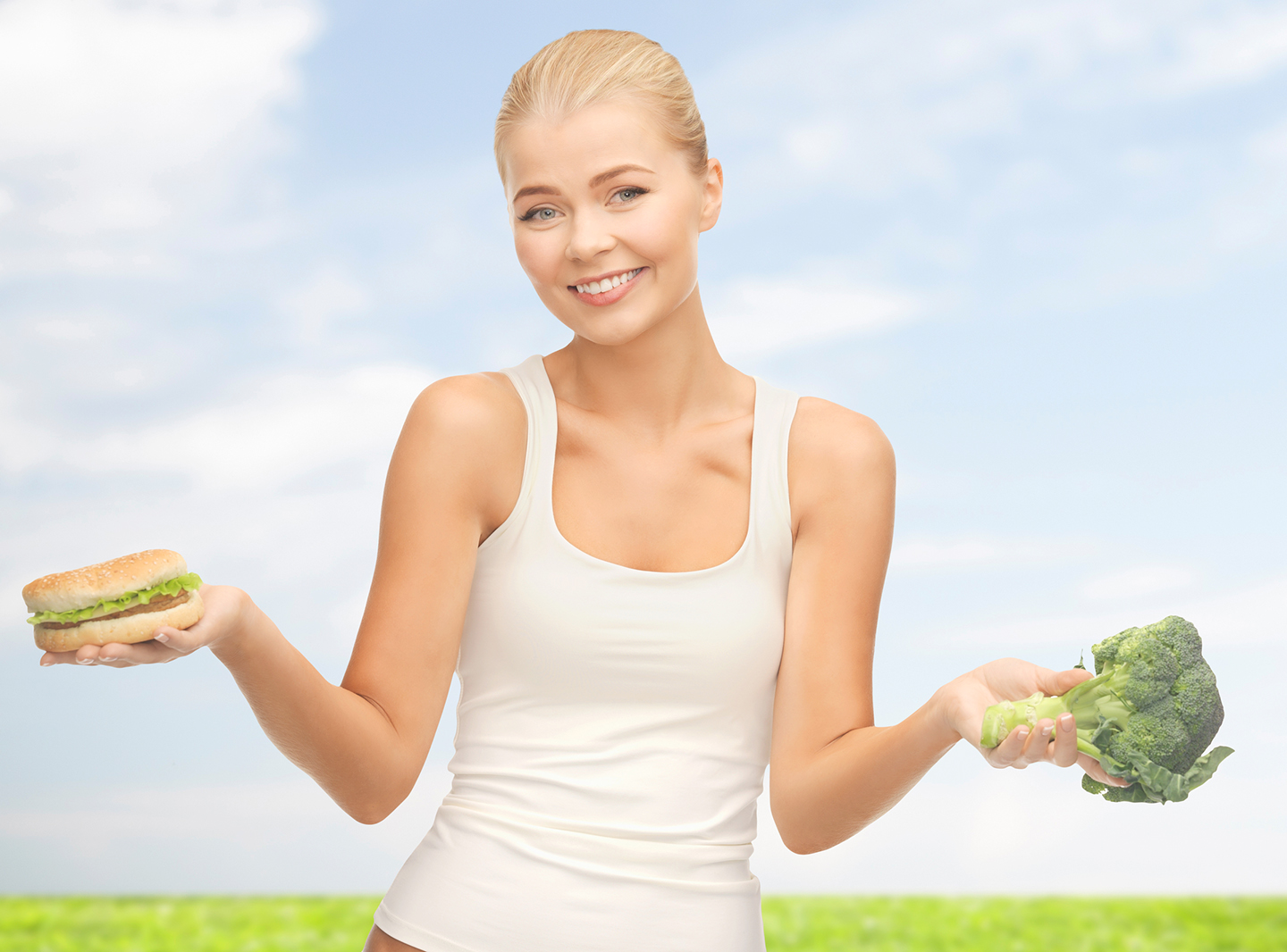 smiling woman with broccoli and hamburger