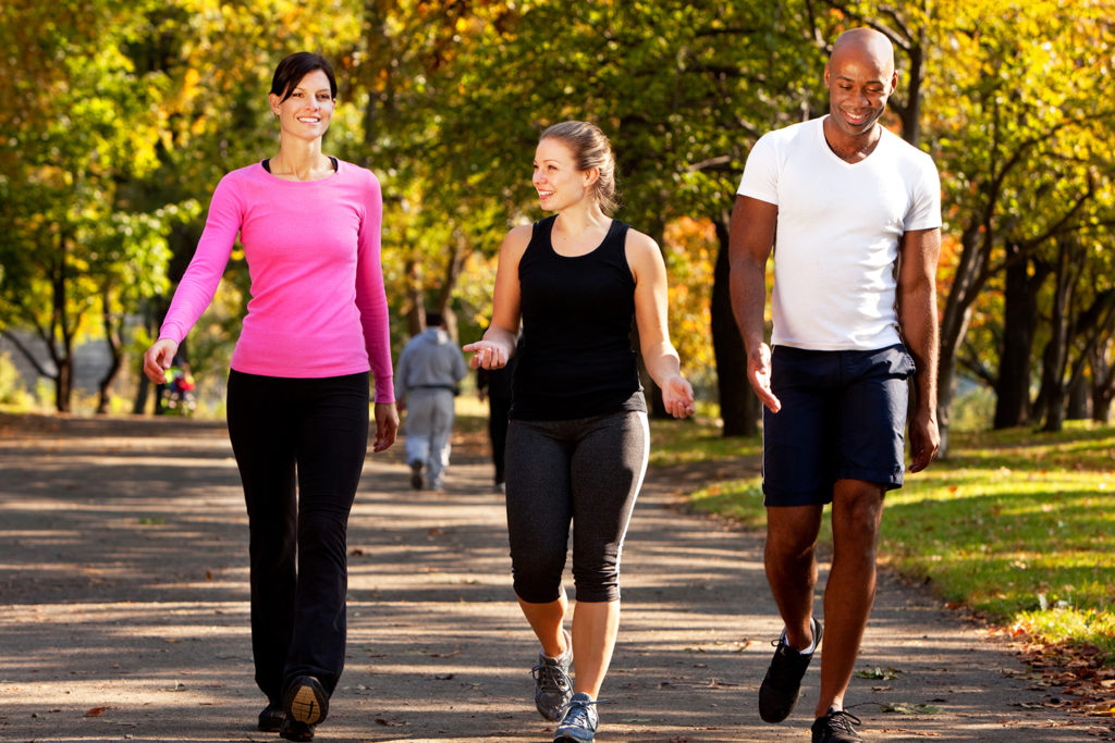 Three people walking in a park, getting some exercise