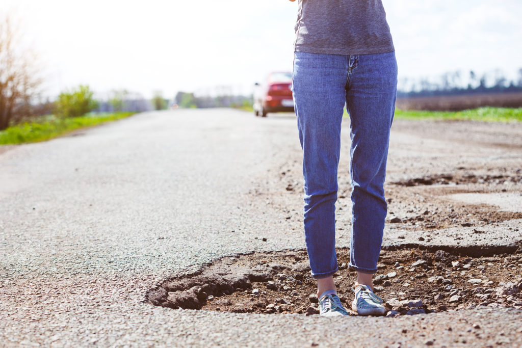 Woman standing in a pothole