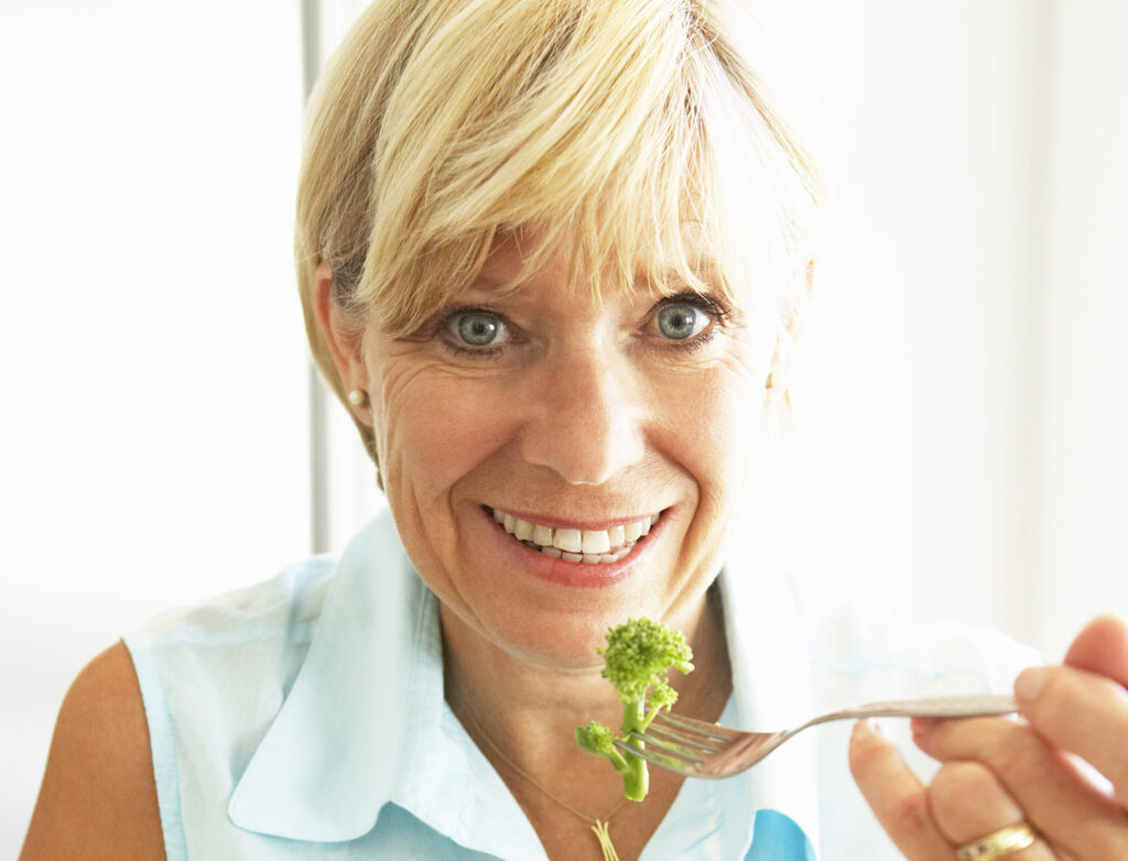 Woman eating broccoli